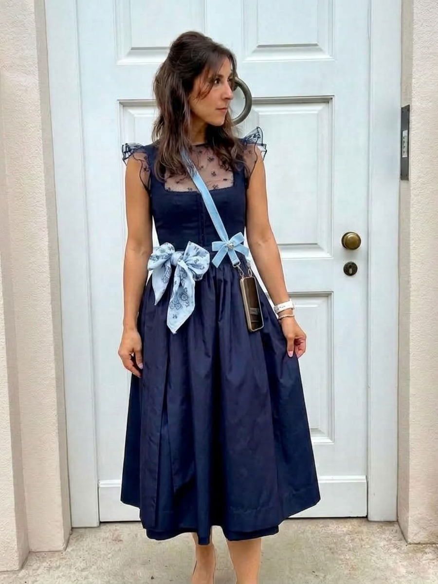 Frau mit Dirndl mit Handyband aus Samt in hellblau